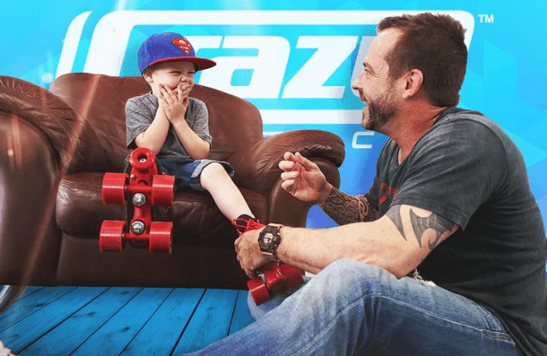 father and son putting skates on smiling at each other